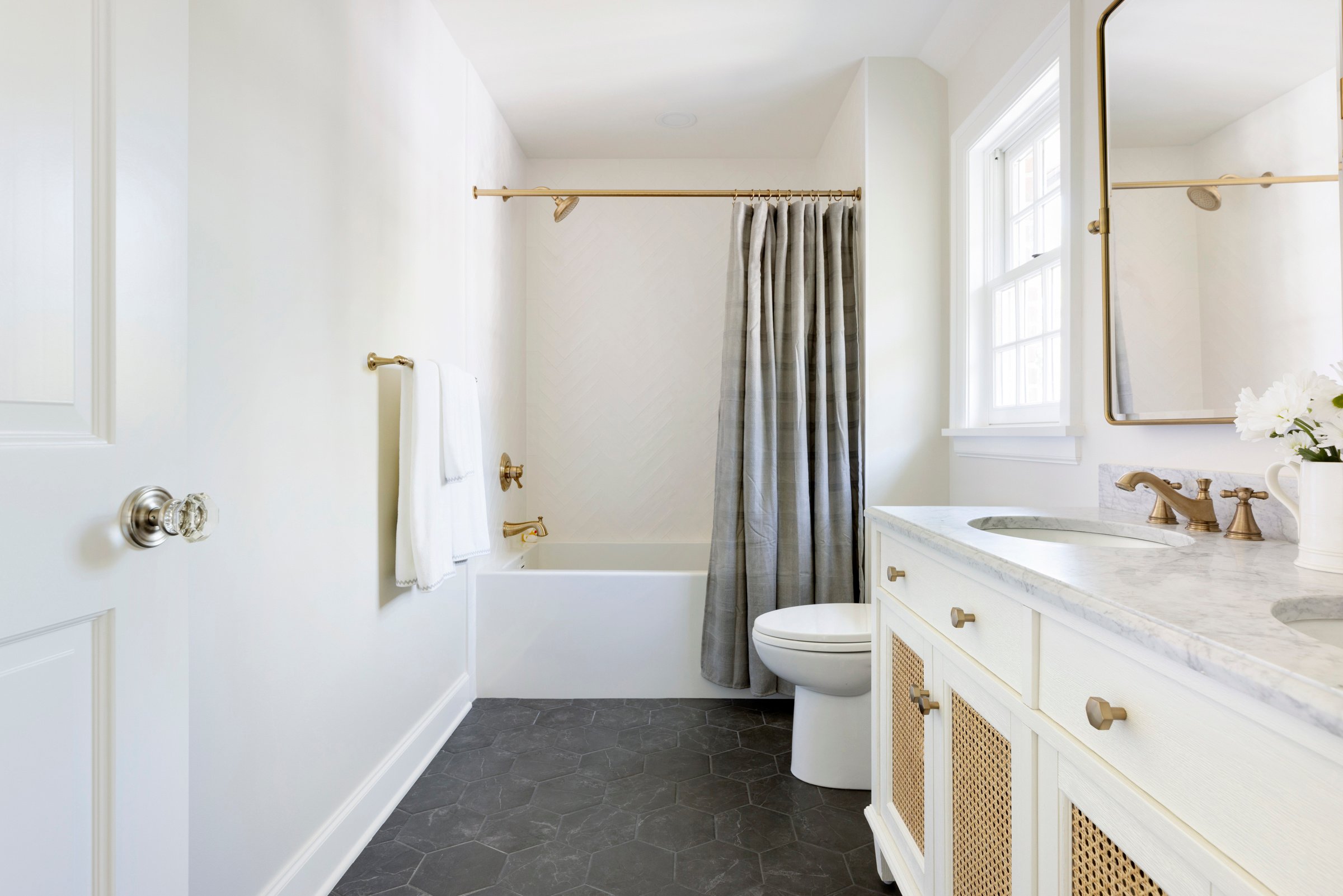 Luxury bathroom design with double sinks, backlit mirrors, and custom cabinetry.