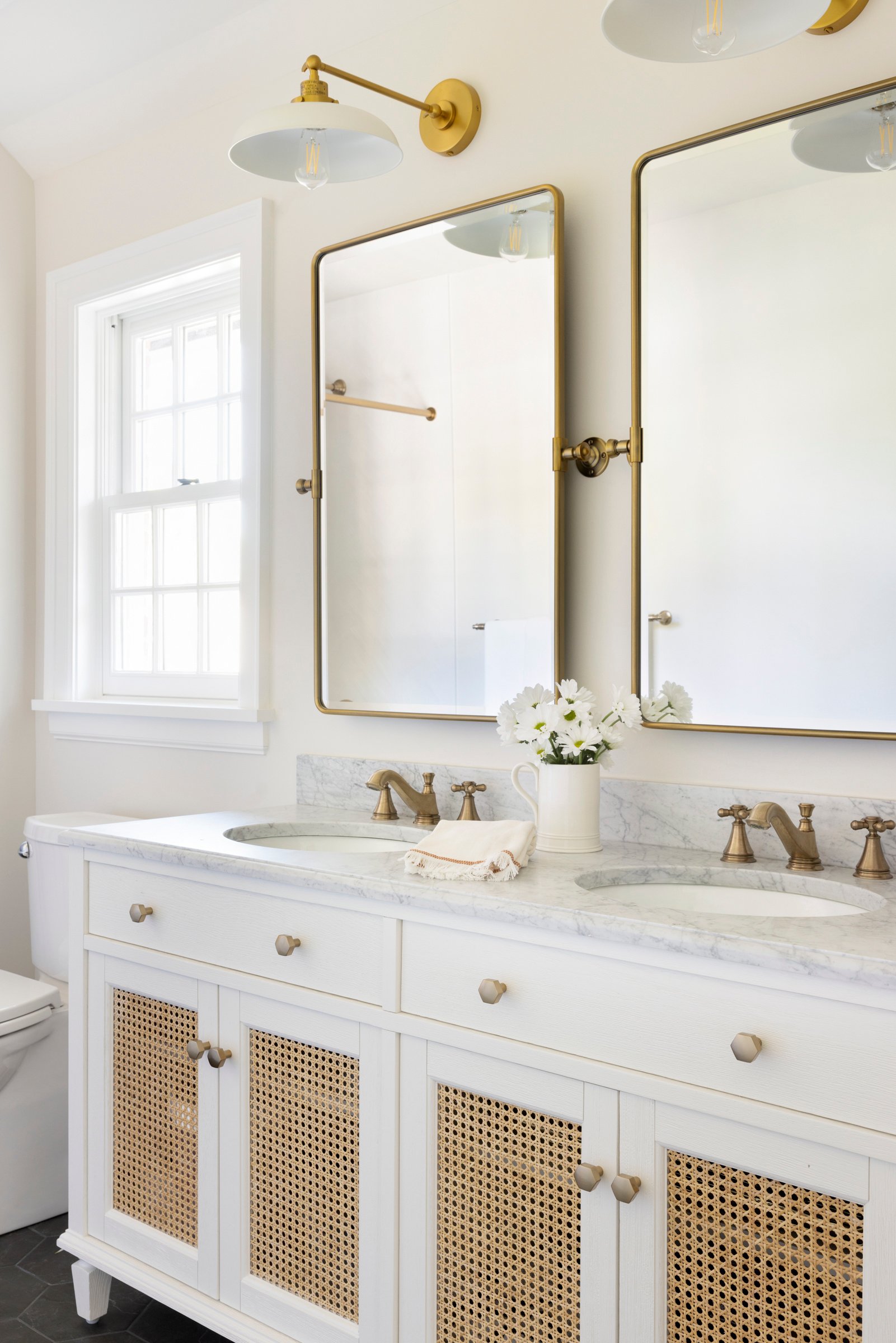 Luxury bathroom design with double sinks, backlit mirrors, and custom cabinetry.