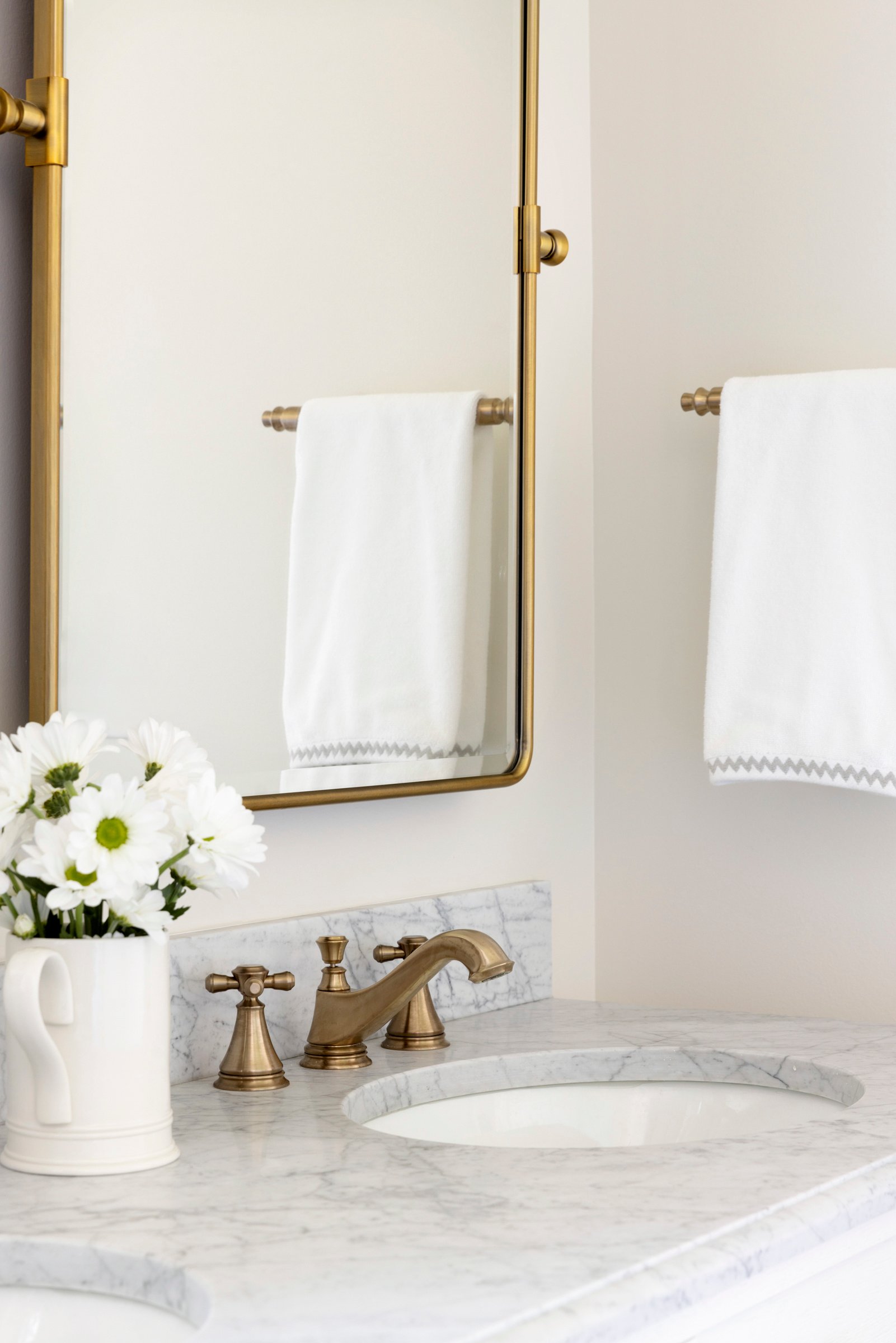 Luxury bathroom design with double sinks, backlit mirrors, and custom cabinetry.